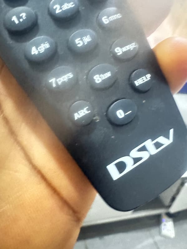 Holding the ARC and Standby buttons to reset a DStv A6 remote.