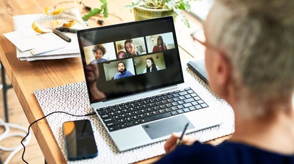 Person participating in a multi-person Zoom video call on a laptop