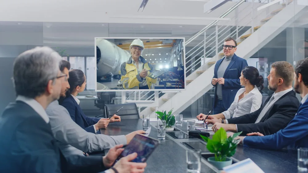 Business team in a modern meeting room watching a presentation on a large screen during a professional discussion