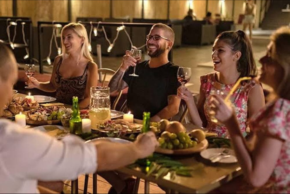 Happy group of friends dining and raising glasses in a modern restaurant